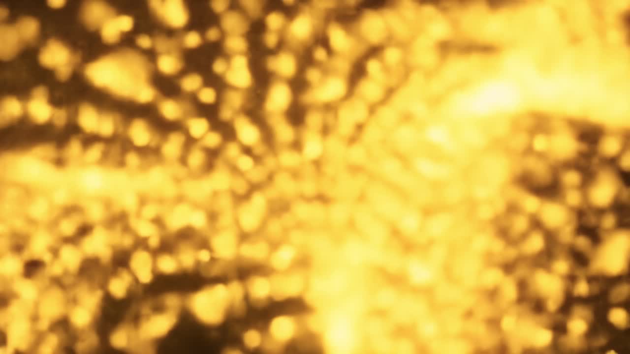 Dazzling golden lights twinkle and swirl, creating a captivating ambiance at a city celebration. The vibrant colors transform the evening into a magical experience for attendees.