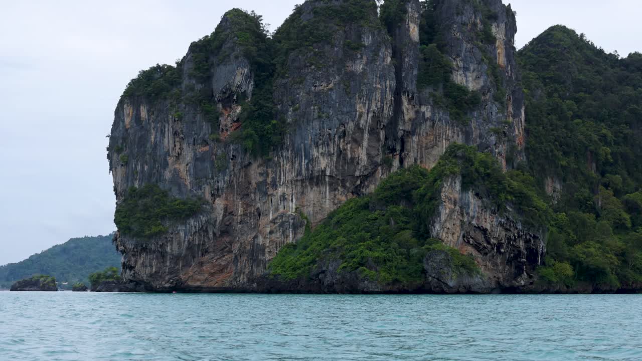 울창한 초록색과 바다가 있는 바위 섬