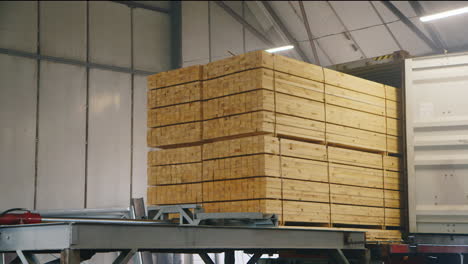 A-large-stack-of-timber-is-loaded-into-a-container-ship