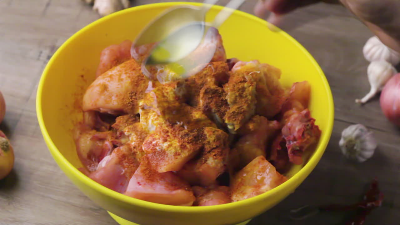 adding mustard oil into the chicken marination by chef