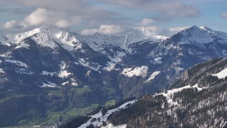 Drone-captured-wide-shot-of-beautiful-snowy-mountains-of-Glarus,-Switzerland