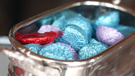 colorful foil-wrapped chocolates in a silver bowl