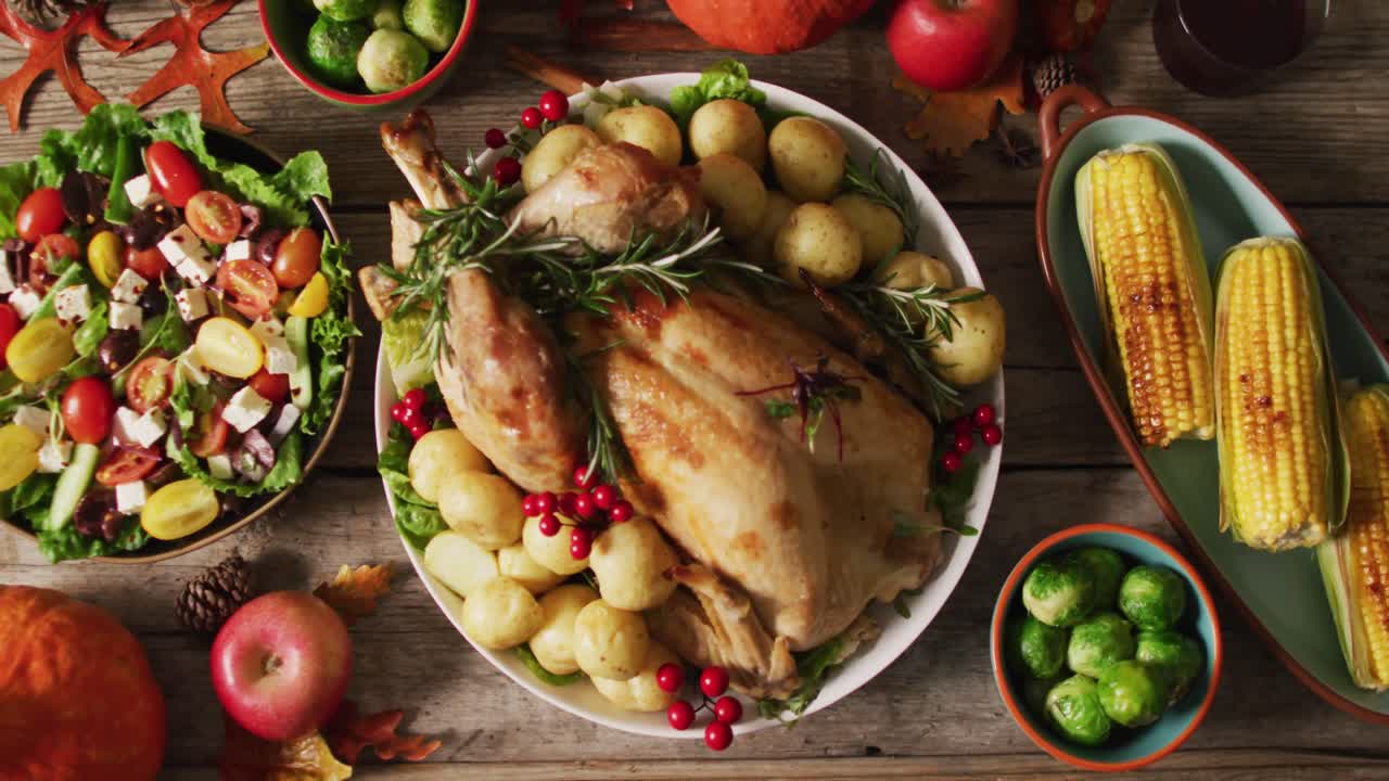 video de bandeja con pavo asado, platos diversos y decoración de otoño en superficie de madera