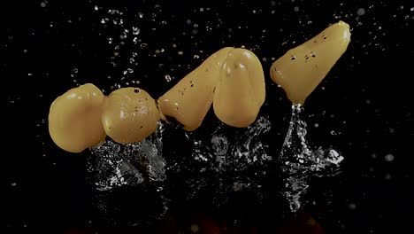 un pimiento salpica en el agua, sus colores vibrantes contrastan contra un fondo negro, evocando un concepto de frescura y vitalidad