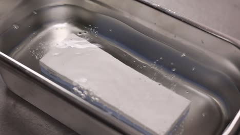 piedra de afilar en el baño de agua