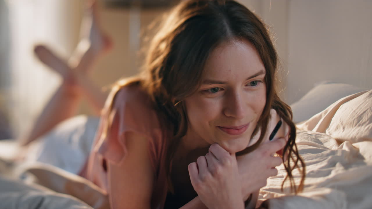 집에서 스마트폰을 들고 있는 기쁜 소녀. 웃는 만적 인 여성 휴식