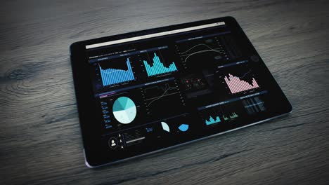 La-Tableta-Sobre-Una-Mesa-De-Madera-Muestra-Animación-Con-Diagramas,-Conjuntos-De-Datos,-Curvas-E-Información-Para-Pantallas,-Monitores-Y-Paredes-Digitales