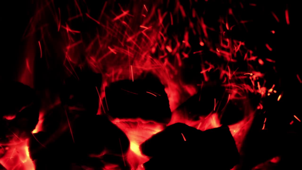 Braci di carbone rosso incandescenti con scintille volanti