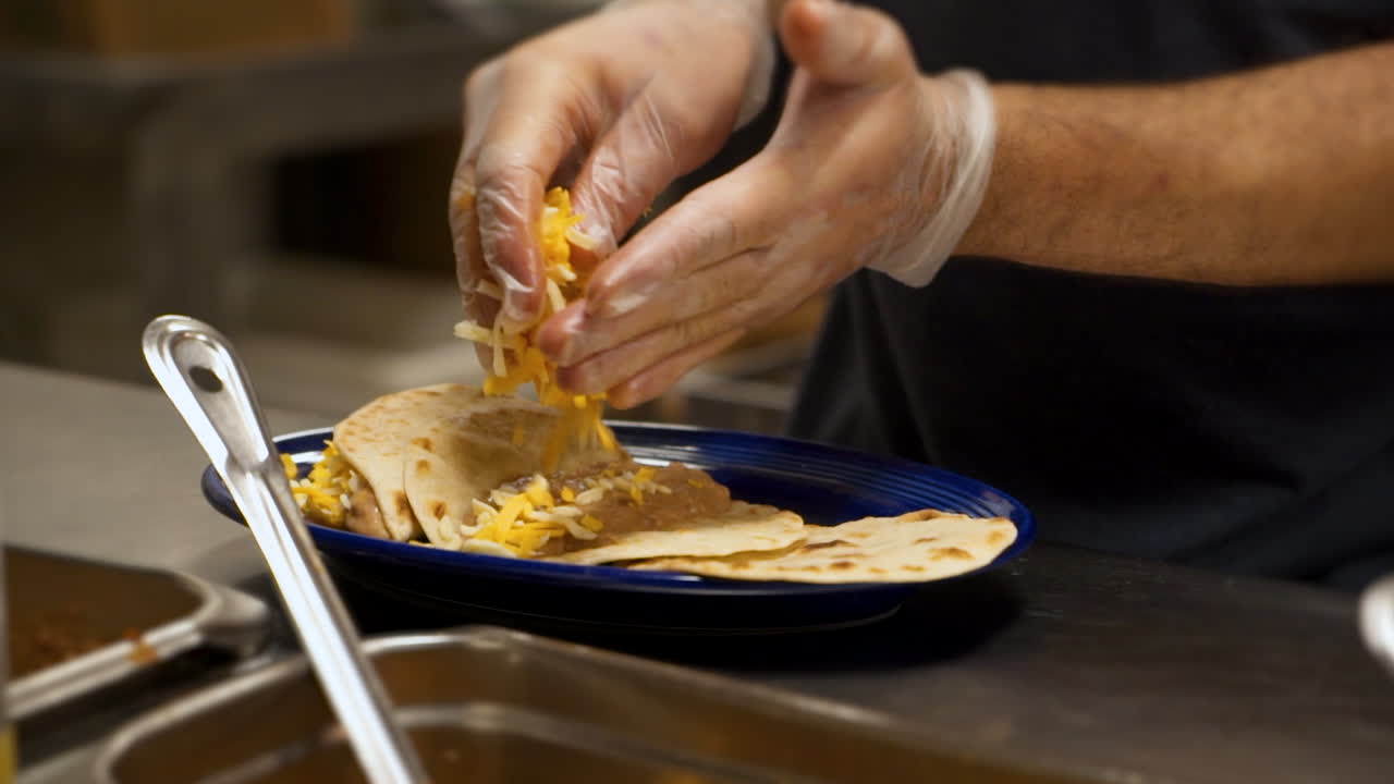 cocinero prepara tacos de frijol y queso en la cocina del restaurante mexicano, hd en cámara lenta