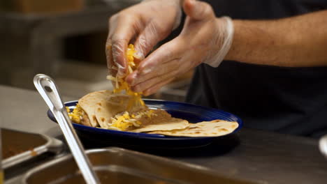 cook prepares bean and cheese tacos in mexican restaurant kitchen, slow motion hd