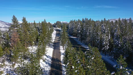 drone shot over traffic on the i-80 in the snowy mountains of sunny tahoe, usa