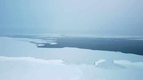 Drone-Volando-Sobre-Agua-Congelada-Mañana-Nevada,-Calentamiento-Global-Y-Cambio-Climático---4k