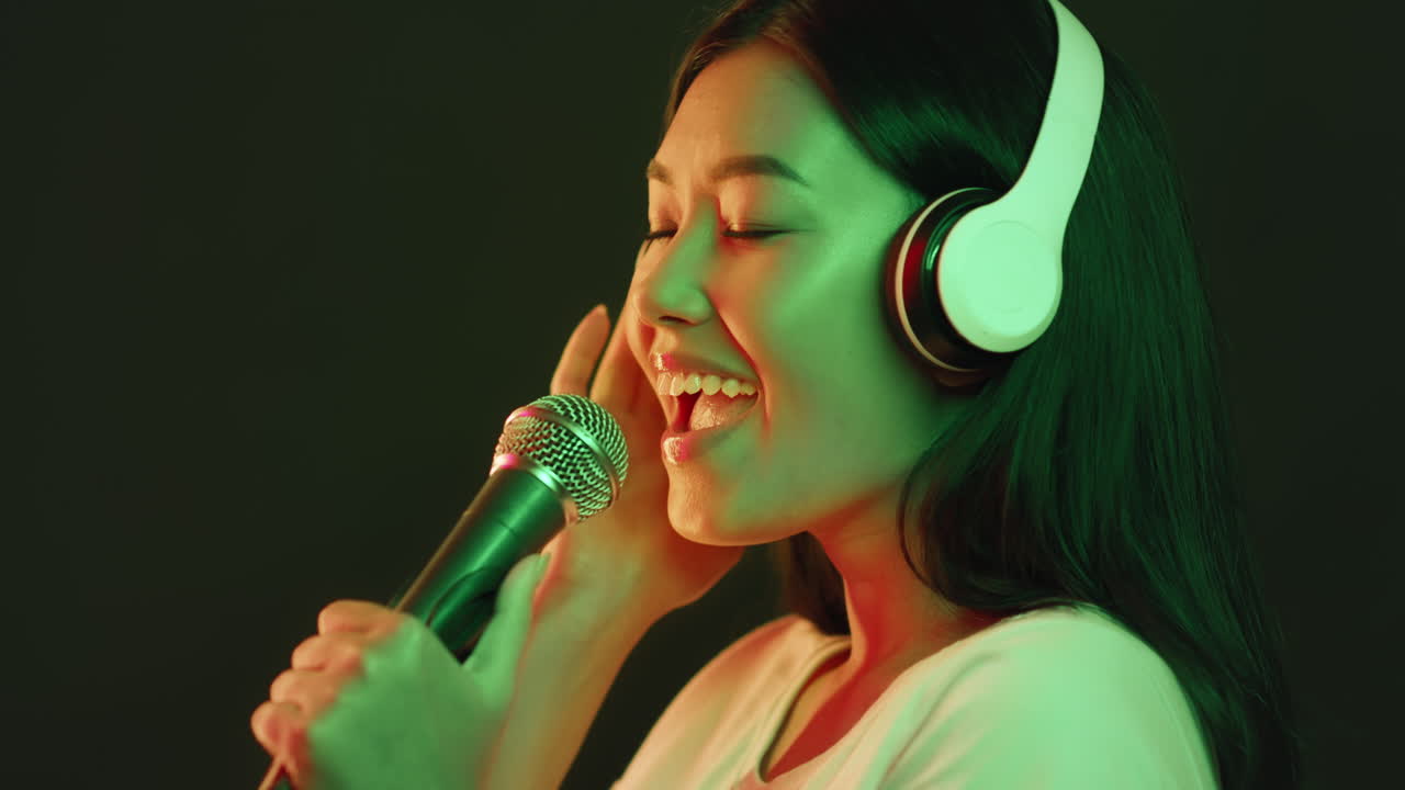 Woman Singing Into a Microphone with Headphones