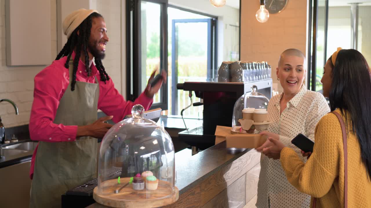 Customers approaching cafe counter, male barista serving coffees, refreshing display, copy space