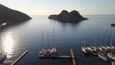 aerial view of cifltik bay,footage over sailboats stern-to a restaurant's piers forward towards to the open sea and islands.