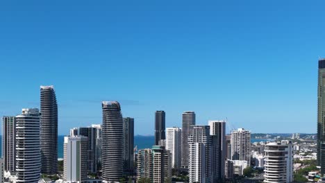 aerial footage of gold coast's skyline under clear blue skies, showcasing modern skyscrapers and coastal views