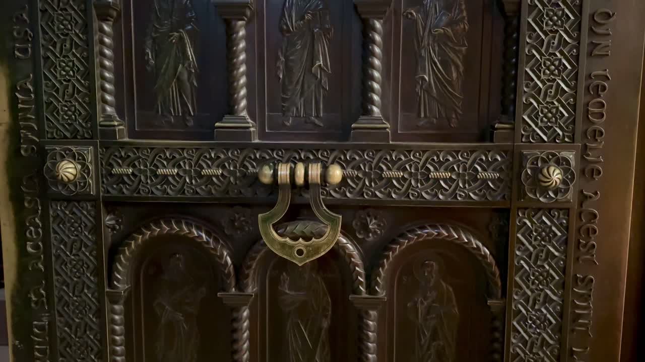 Iasi'deki Üç Kutsal Hiyerarh Manastırı'nda karmaşık oymalar, dini semboller ve yazıtlarla süslü çelik kapı