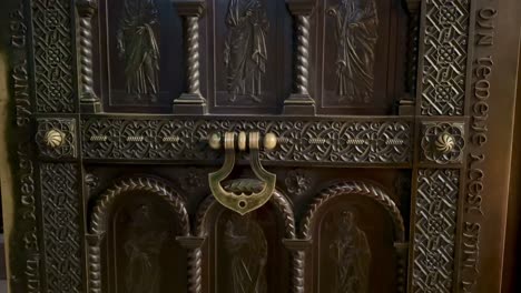 ornate steel door with intricate carvings, religious symbols, and inscriptions at three holy hierarchs monastery, iasi.