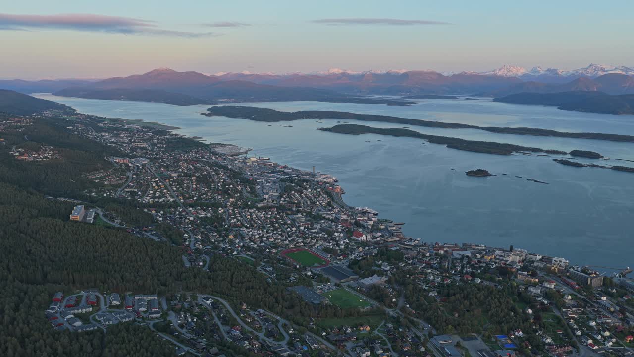 La città di Molde si estende lungo la costa del fiordo al tramonto, panorama da drone