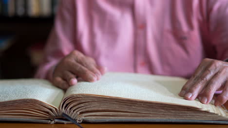 un anciano leyendo un libro en braille