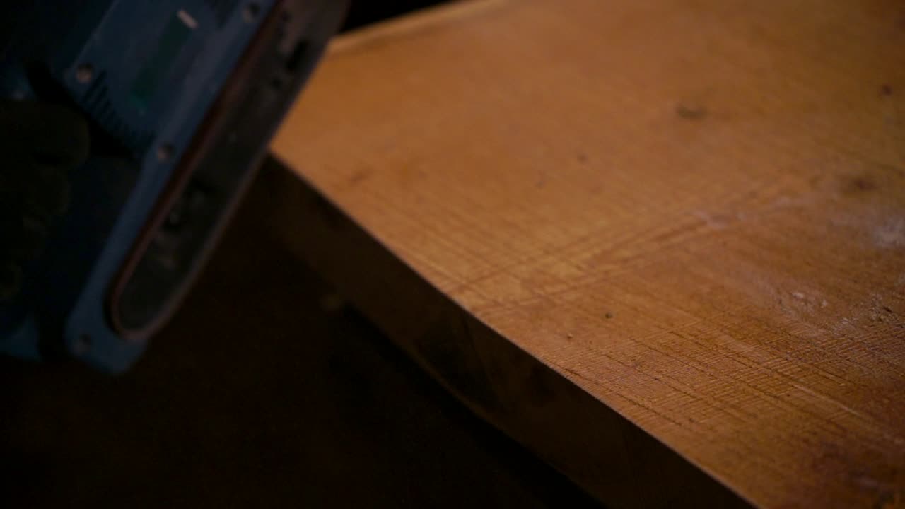 persona que lijaba madera con una lijadora eléctrica