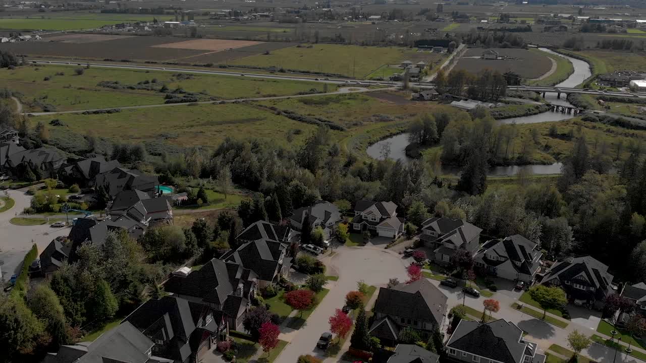 Drone 4K-optagelser af Cloverdale byboliger for middelklasseborgere. Zoneret byplanlægning nær et beskyttet grønt bælte med panorama og majestætisk topografi.