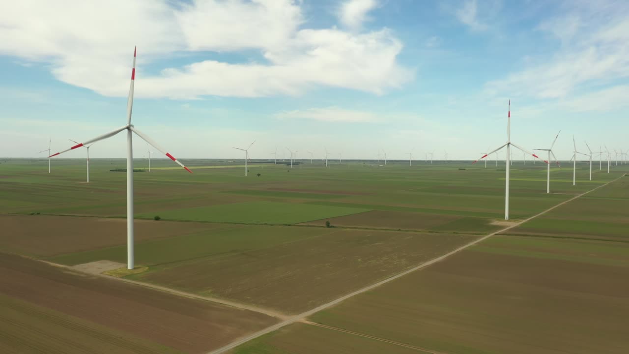 View of several windmills, wind generators, turbines, producing renewable clean energy by converting kinetic energy