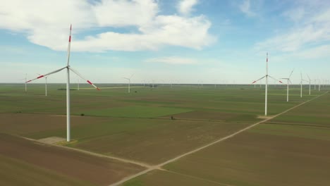 view of several windmills, wind generators, turbines, producing renewable clean energy by converting kinetic energy
