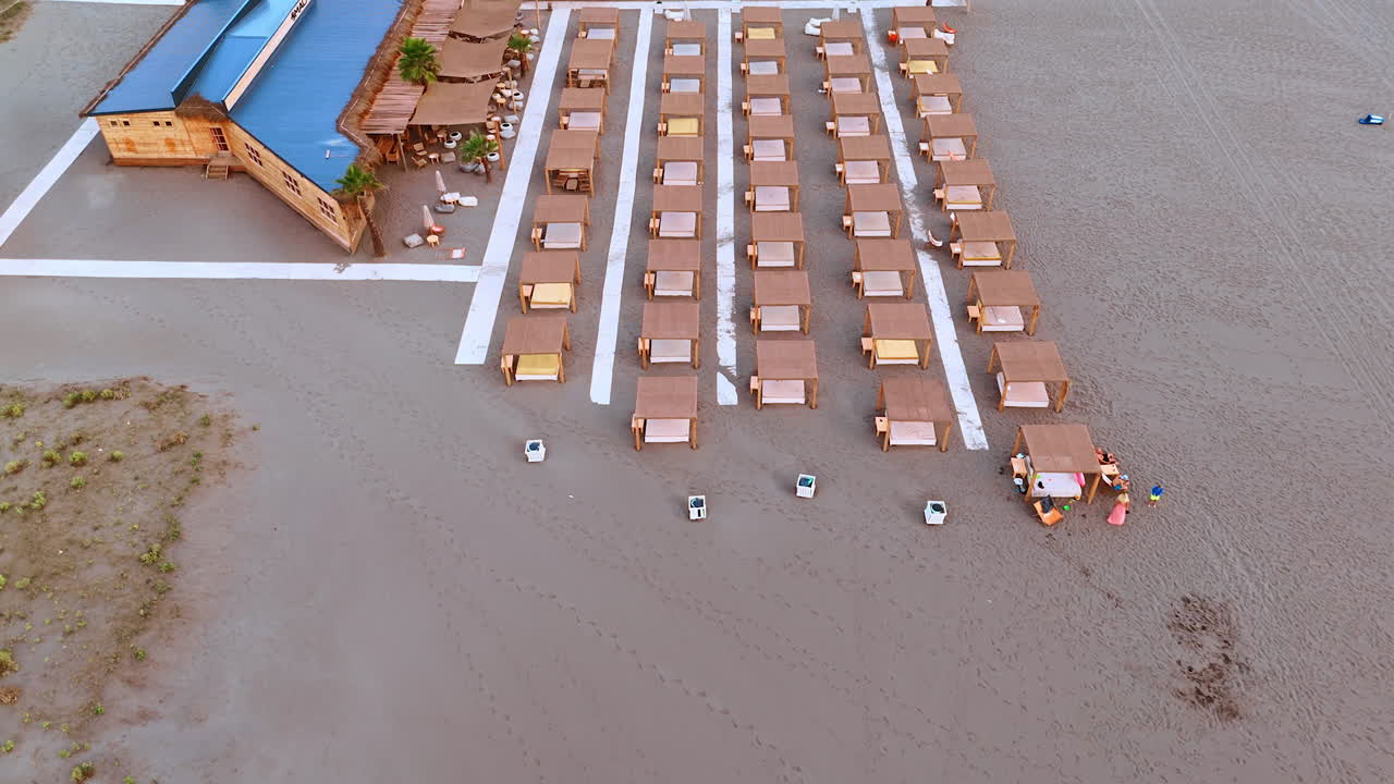 Ulcinj, Montenegro, 14 de agosto de 2025: Linhas aéreas de barracas de praia. Layout geométrico de barracas na praia arenosa de Montenegro visto de cima