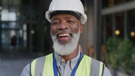 portrait senior african american construction engineer man smiling enjoying professional engineering career wearing hard hat safety helmet slow motion reflective clothing