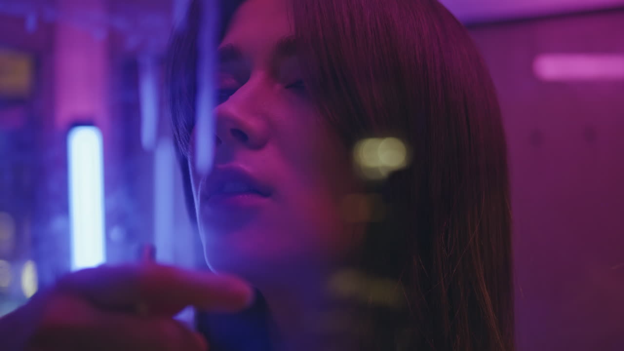 Smoking woman posing neon city closeup. Romantic model looking camera resting