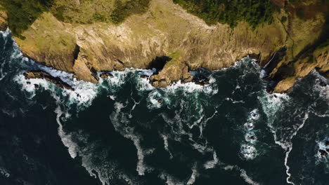 Afternoon-sun-on-rugged-cliffs-along-Oregon-Coast,-Pacific-Ocean