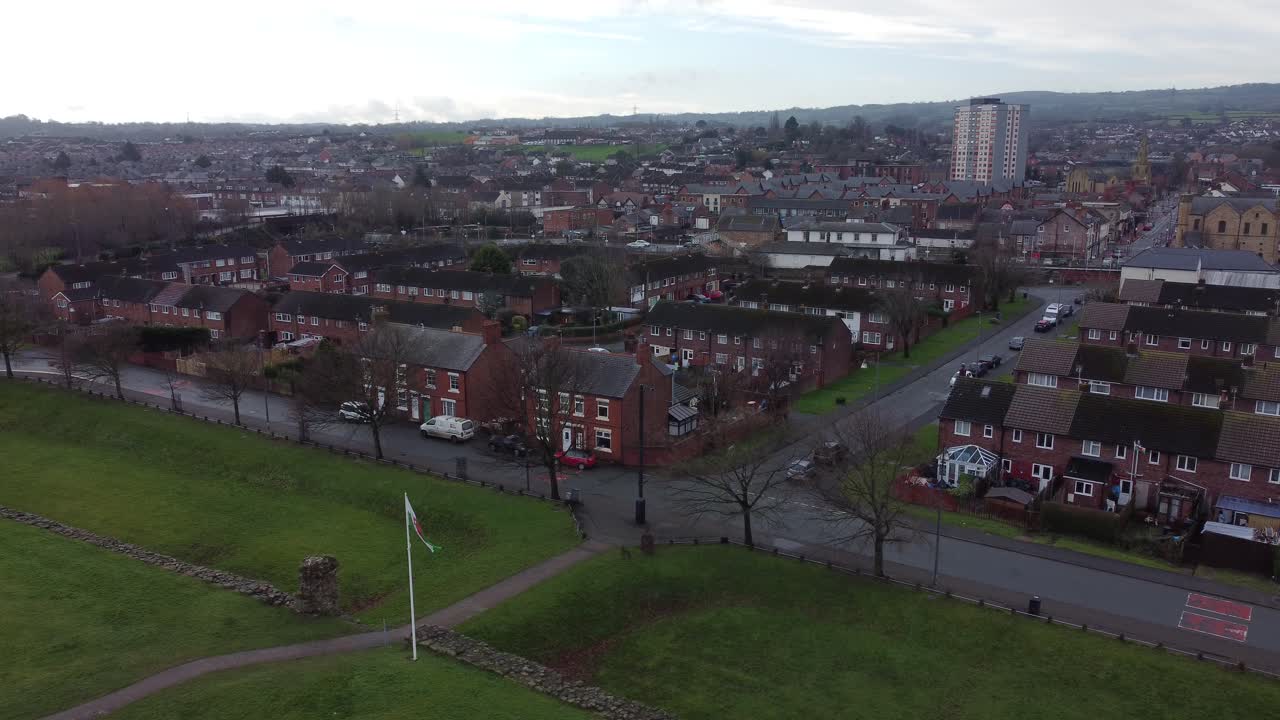 soplando la bandera galesa en flint urbanización antena suburbana calle de la ciudad de gales del norte descendiendo lentamente