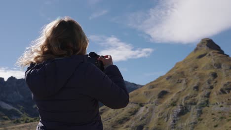 Female photographer takes picture of mountain at Durmitor, Montenegro