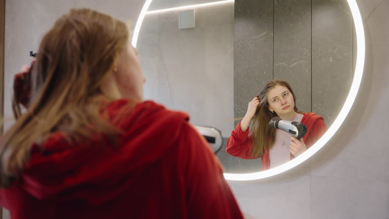 Donna che si asciuga i capelli in bagno