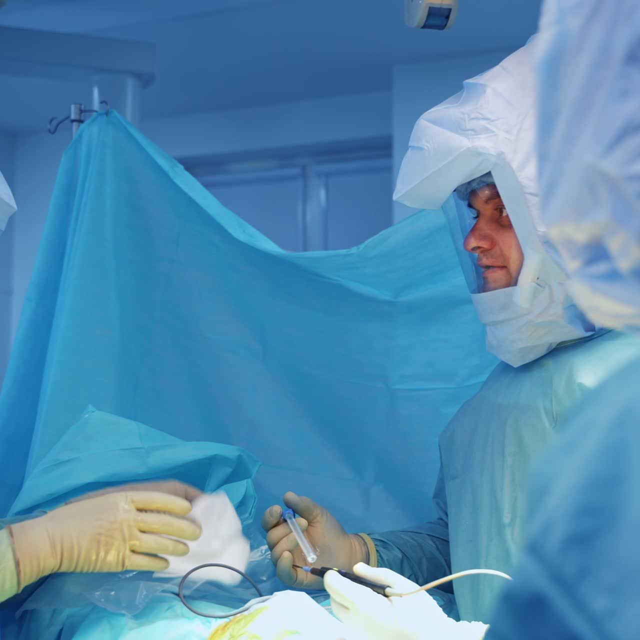 Surgery professionals in protective suits take necessary instruments. Team of doctors starting trauma surgery