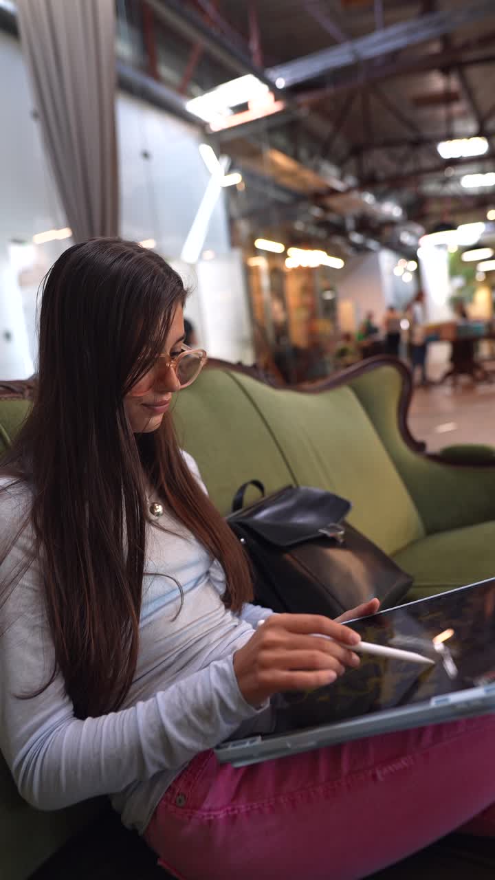 joven trabajando en una tableta digital en un acogedor café