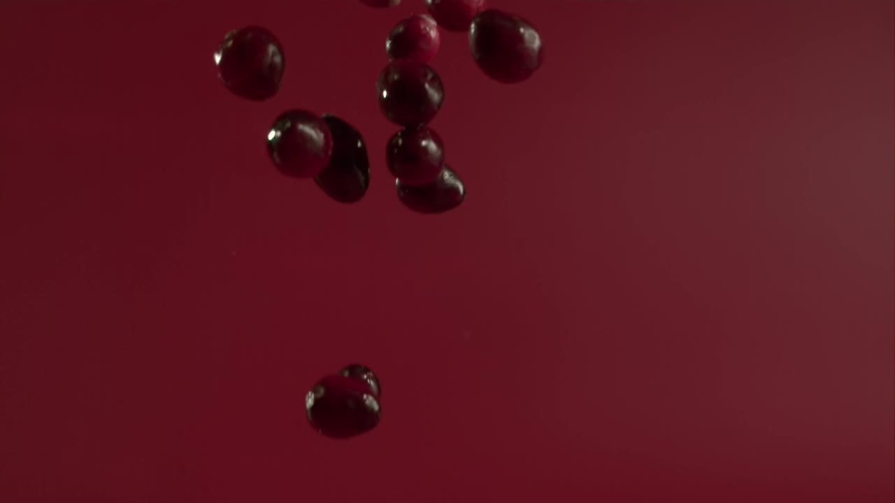 arándanos cayendo rebotando en el suelo húmedo en cámara lenta