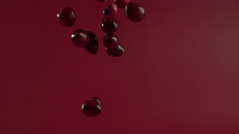 cranberries falling bouncing on wet ground in slow motion