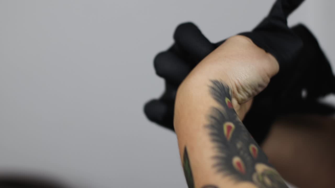 tatuador poniéndose guantes quirúrgicos para trabajar