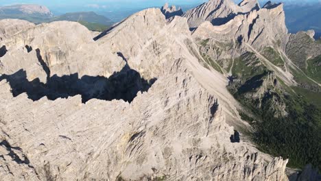 aerial perspective of the dolomites, revealing the vast expanse of jagged rock formations juxtaposed against lush green valleys