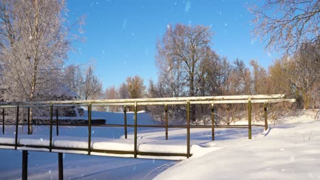 steel walk bridge over frozen lake during light snowfall, beauty of nature