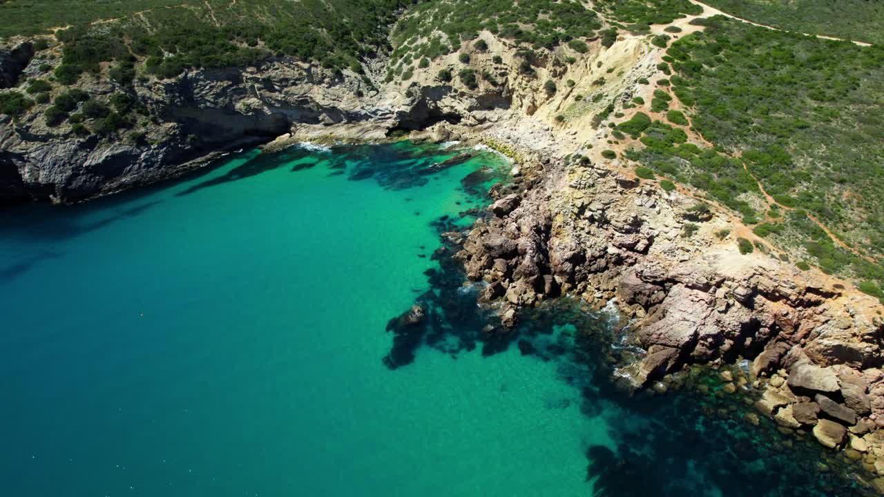 Vista Aérea de Enseada com Águas Cristalinas e Turquesa e Litoral Rochoso no Verão