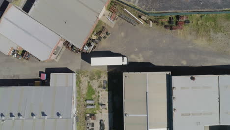 white truck pulling into factory loading area for it's next pickup and delivery