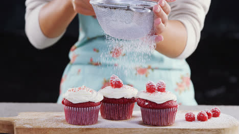 woman icing sugar powder on on cupcakes 4k