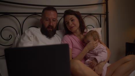 family watching a video together in bed