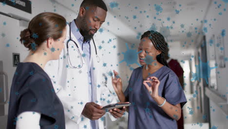 animation of floating viruses over diverse doctors talking in hospital corridor