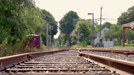 mirando hacia abajo un conjunto de vías de tren en una señal de cruce mientras pasa el automóvil