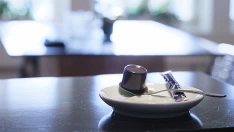 close up shot of a hand taking and putting a cup of steaming coffee from table in cafe or restaurant to drink americano or filter coffee at daytime