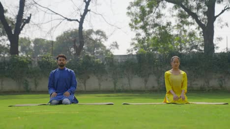 indian couple doing thunderbolt yoga pose